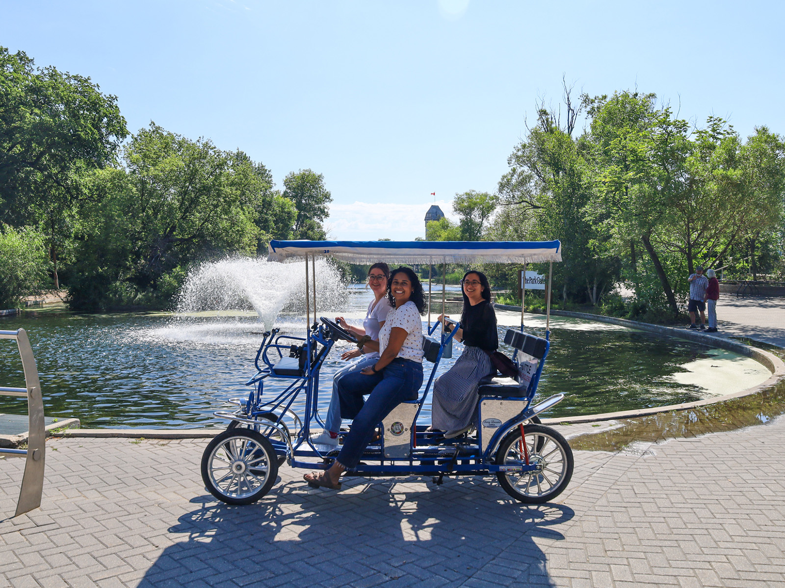 Three women ride on a group bicycle